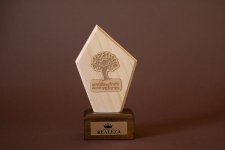 Detalle del reconocimiento de madera con silueta personalizada y placa grabada en la base