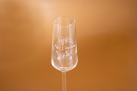 Detalle del grabado láser blanco translúcido en copa de vidrio tipo flauta personalizada