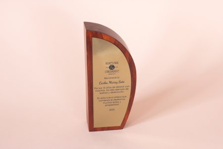 reconocimiento de madera personalizada con tinte rojizo y placa grabada